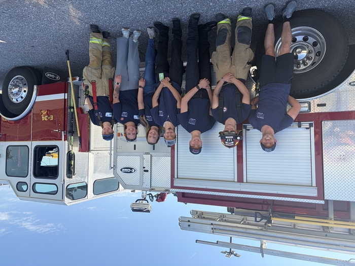 Volunteer firefighters standing near firetruck.